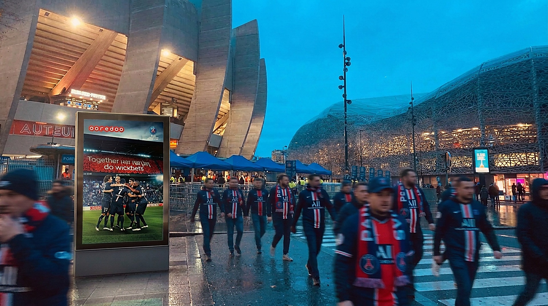 Ooredoo × Paris Saint-Germain — campaign screen outside the Parc des Princes with fans in PSG colours